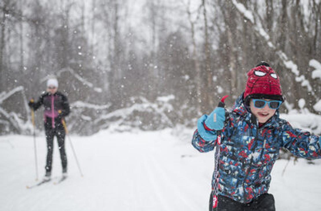 Etualalla innokas nuori hiiht&auml;j&auml; lumisessa mets&auml;ss&auml;. 