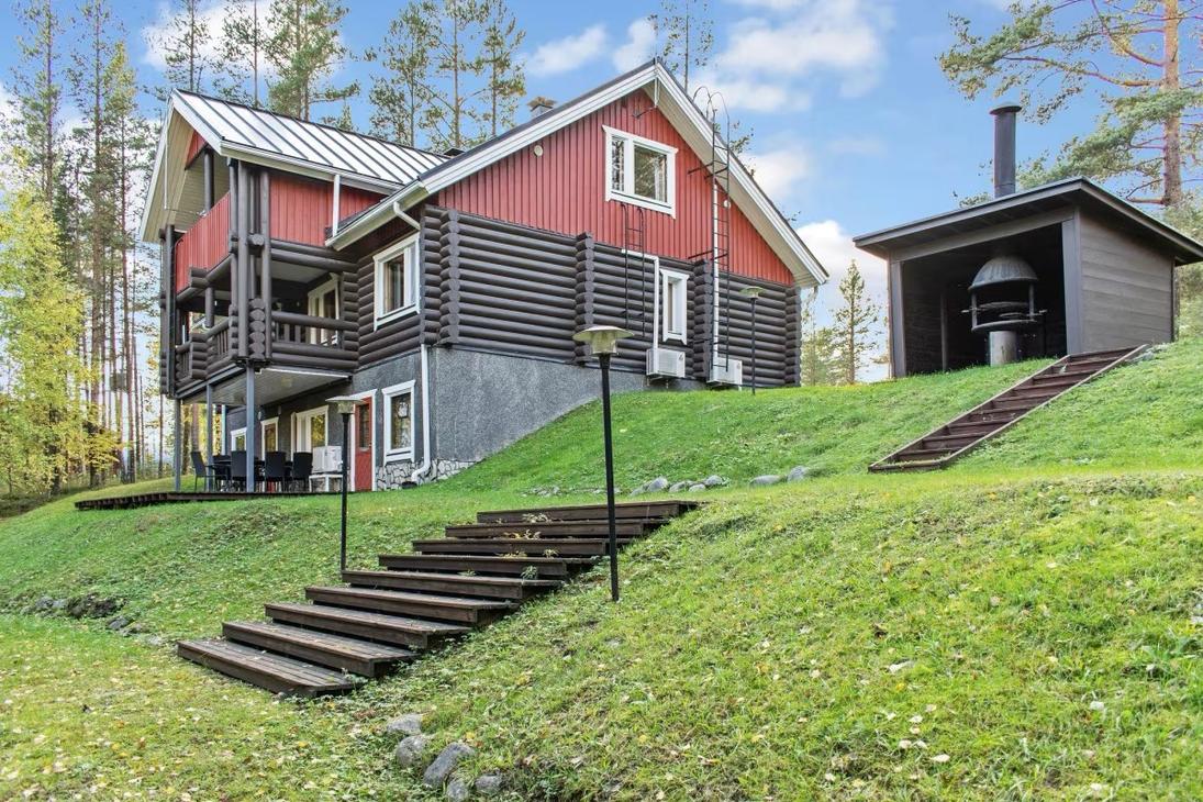 Huvila sekä grillikota nurmirintessä kuvattuna alaviistosta