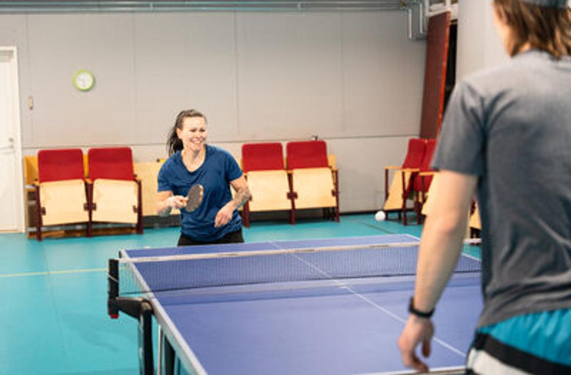 Pöytätenniksen pelaajat liikuntahallilla