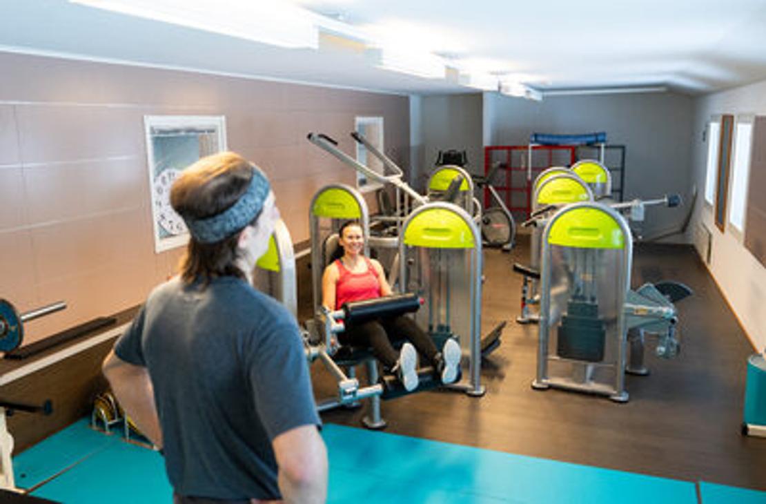 Kolikeskuksen kuntosalin painolaitteita ja salin yleisnäkymä salilta