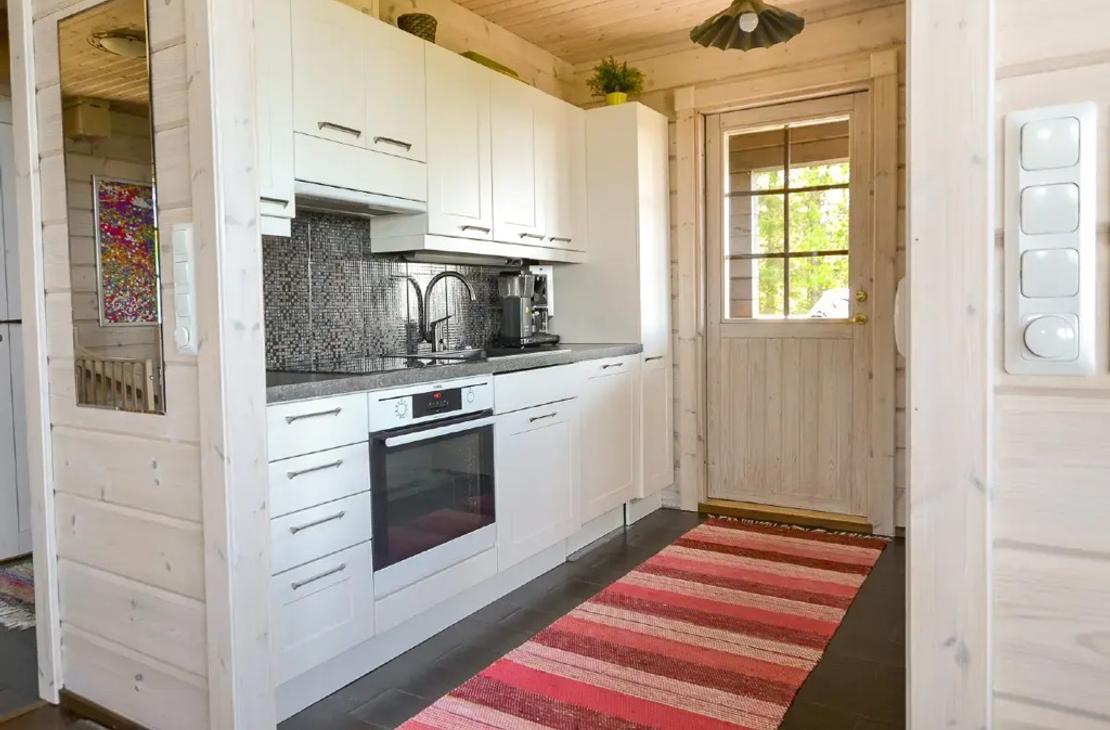 M&ouml;kiss&auml; on valkoiset keitti&ouml;kaapit ja keitti&ouml;st&auml; on k&auml;ynti terassille