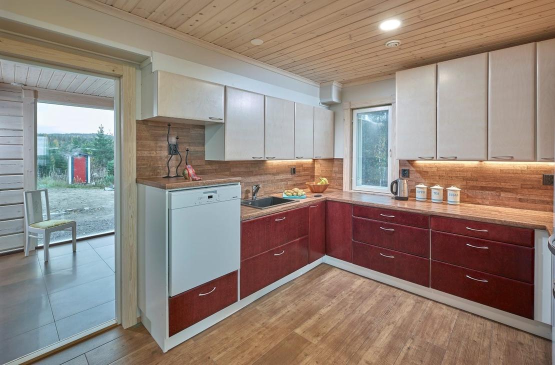 Keittiö on kahdella seinällä. Punaiset alakaapit ja valkoiset yläkaapit