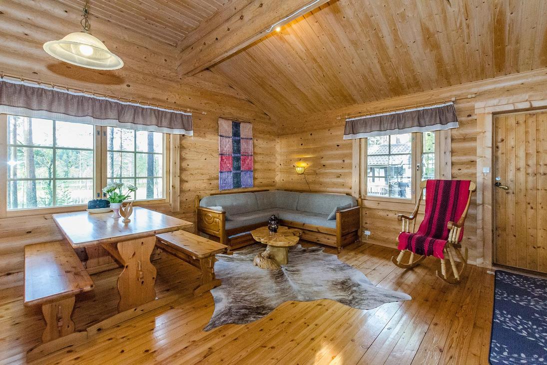 Hirsisen mökin oleskelunurkkaus, jossa pirtinpöytä ja kulmasohva