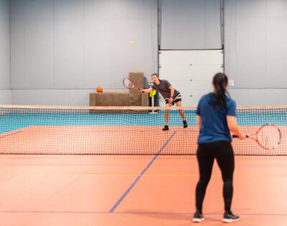 Tenniksen pelaajat liikuntahallilla