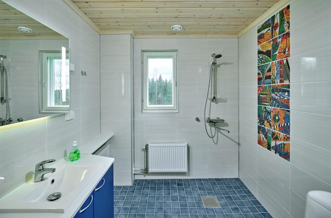 Kylpyhuone, jossa sininen lattia ja valkoiset seinät