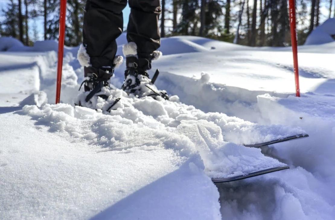 Liukulumikengät aurinkoisella hangella