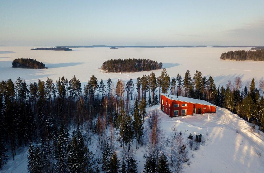 Vaarinkallion punainen huvila pienen m&auml;en laella Pielisen rannassa.