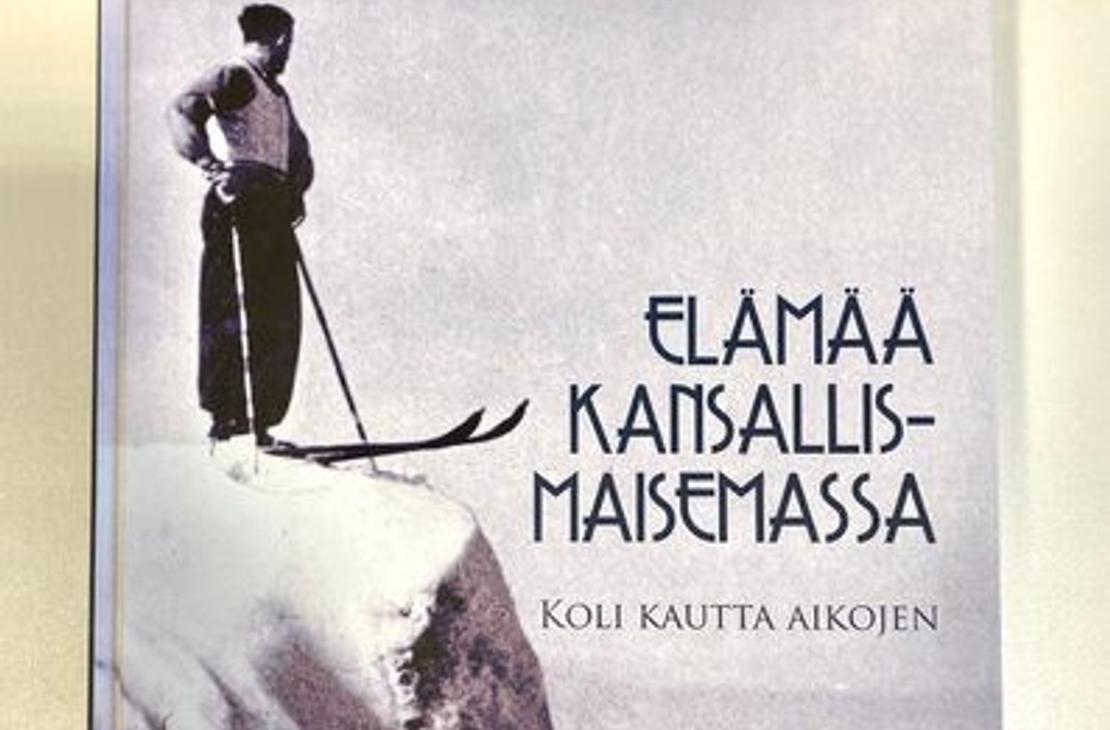 Koli kautta aikojen -kirjan kansi, jossa näkyy hiihtäjä Kolin kalliolla ja kirjan nimi.