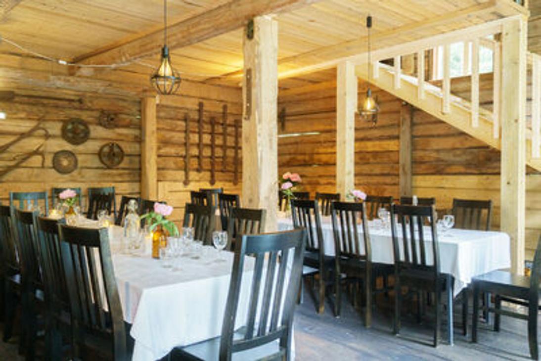 Venejoen Myllyn hirsiset sisätilat, jossa katettuja pöytiä