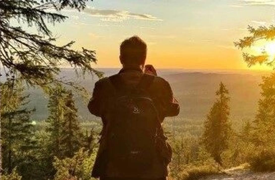 Retkeilij&auml; auringonlaskun aikaan Kolin vaaroilla 