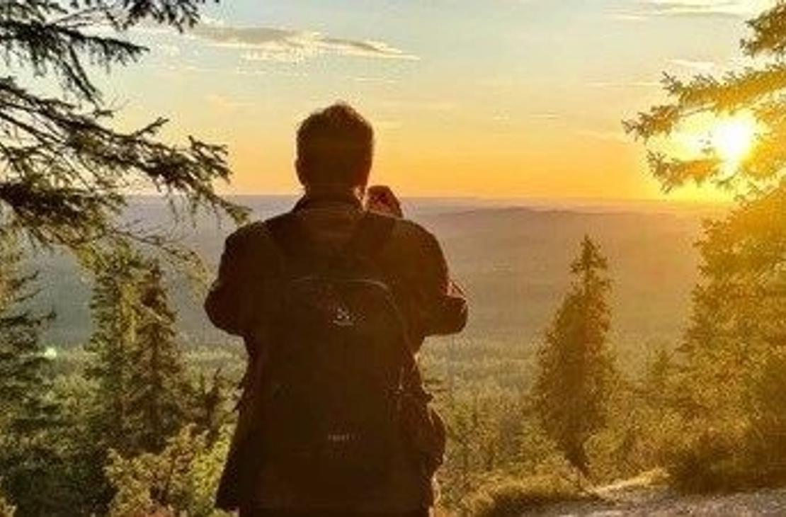 Retkeilij&auml; auringonlaskun aikaan Kolin vaaroilla 