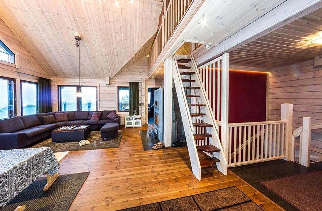 Avarasta vaalean puun sävyisestä oleskelutilasta nousee portaat parvelle