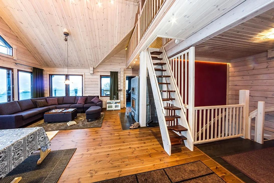 Avarasta vaalean puun sävyisestä oleskelutilasta nousee portaat parvelle