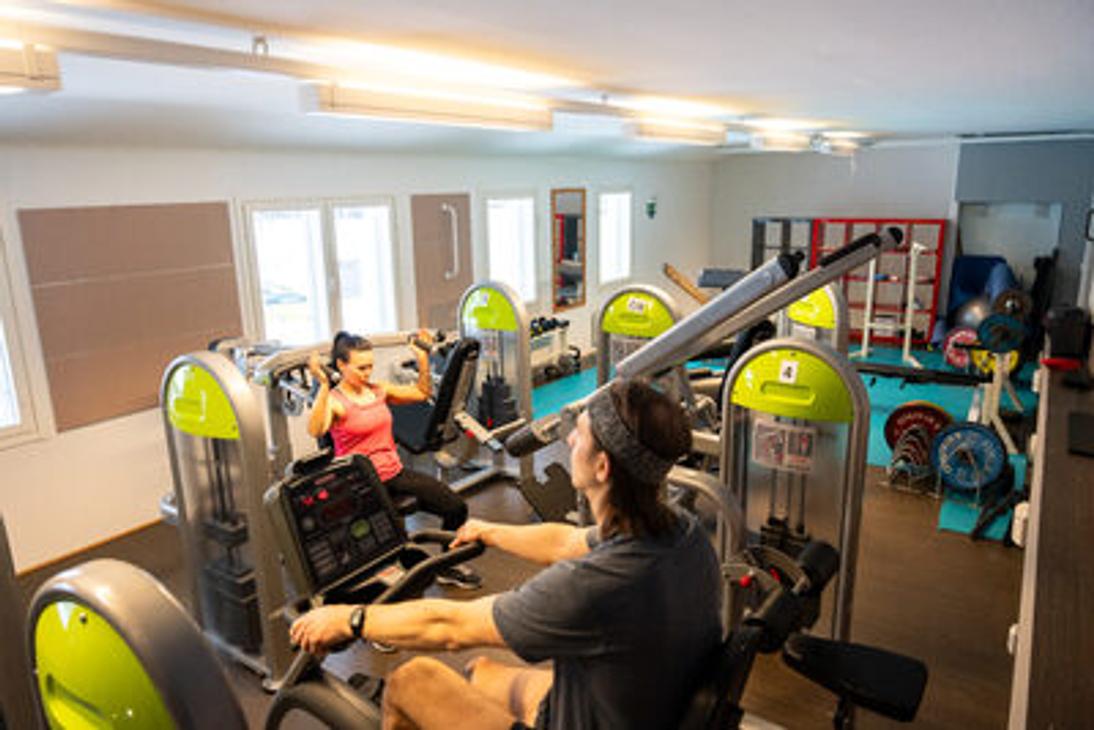 Kaksi henkilöä treenaamassa Kolikeskuksen kuntosalilla kuntosalilaitteissa
