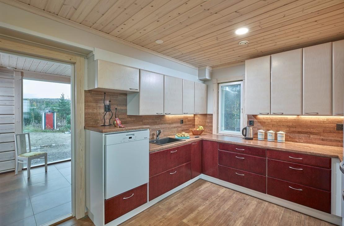 Keittiö on kahdella seinällä. Punaiset alakaapit ja valkoiset yläkaapit