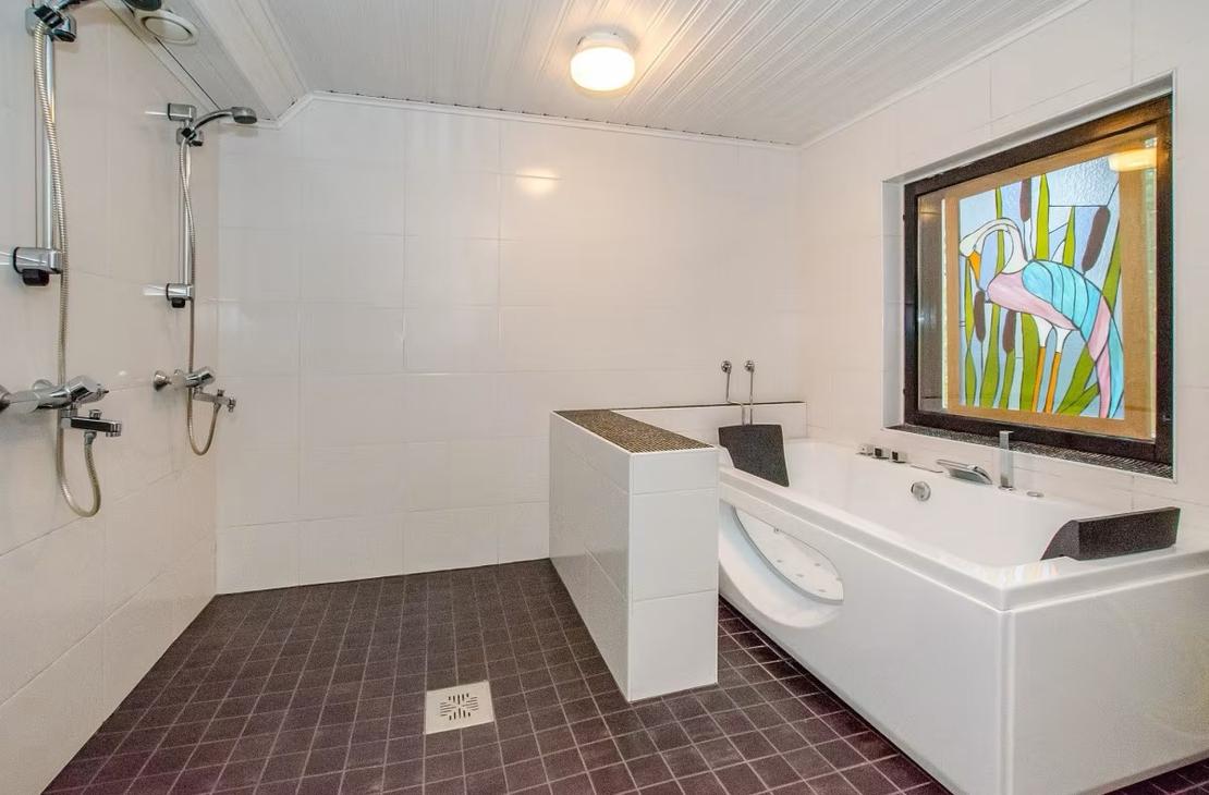 Suihku- ja kylpyhuone, jossa linjakas poreamme.