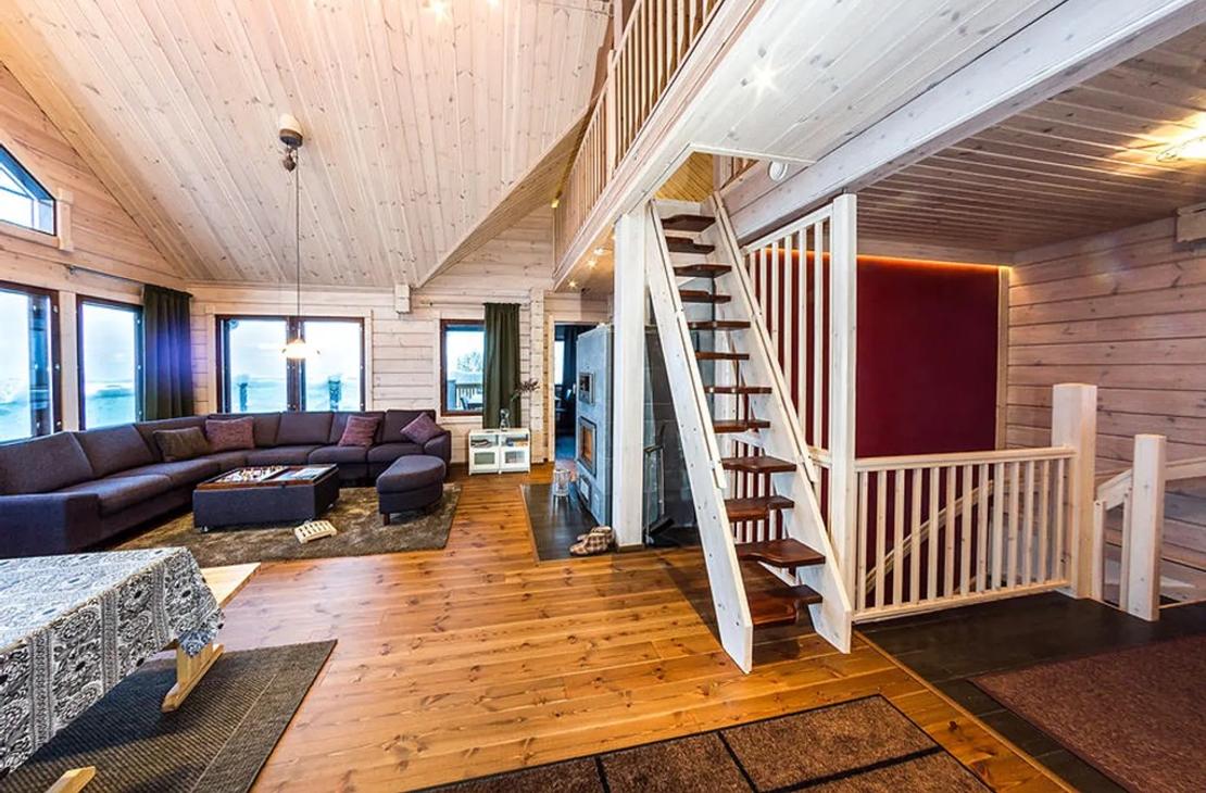 Avarasta vaalean puun sävyisestä oleskelutilasta nousee portaat parvelle