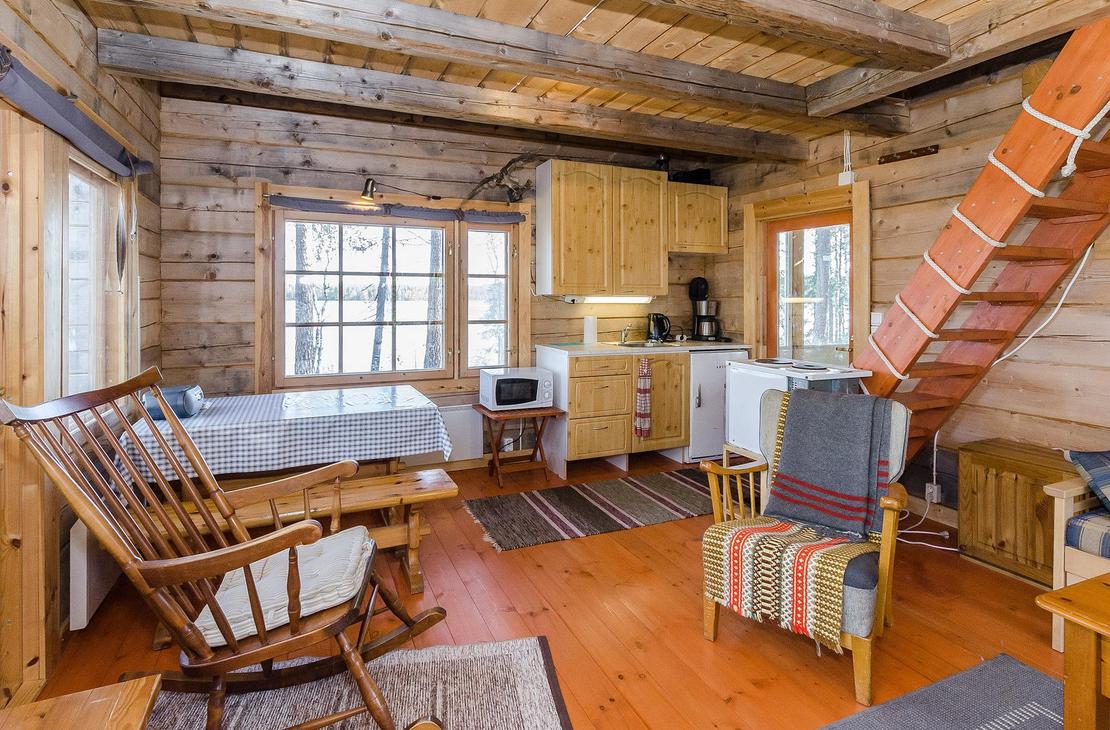 Hirsimökin tupakeittiö, jossa pirtinpöytä ja kiikkutuoli