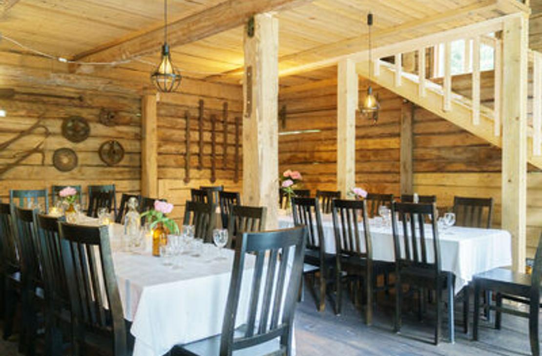 Venejoen Myllyn hirsiset sisätilat, jossa katettuja pöytiä