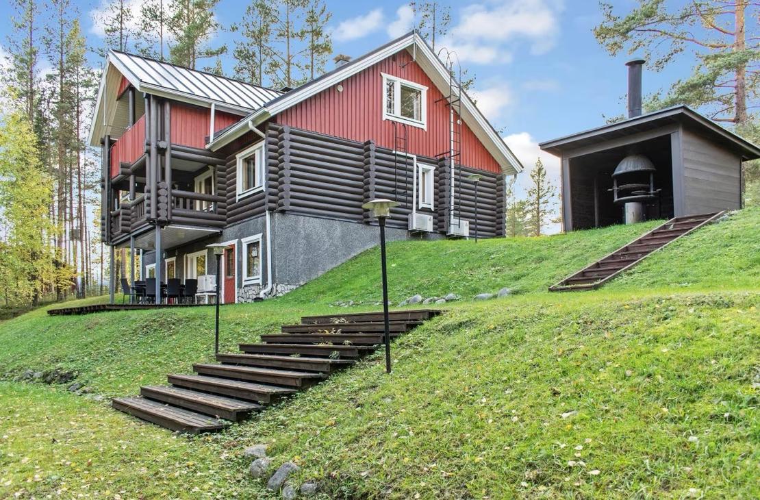 Huvila sekä grillikota nurmirintessä kuvattuna alaviistosta