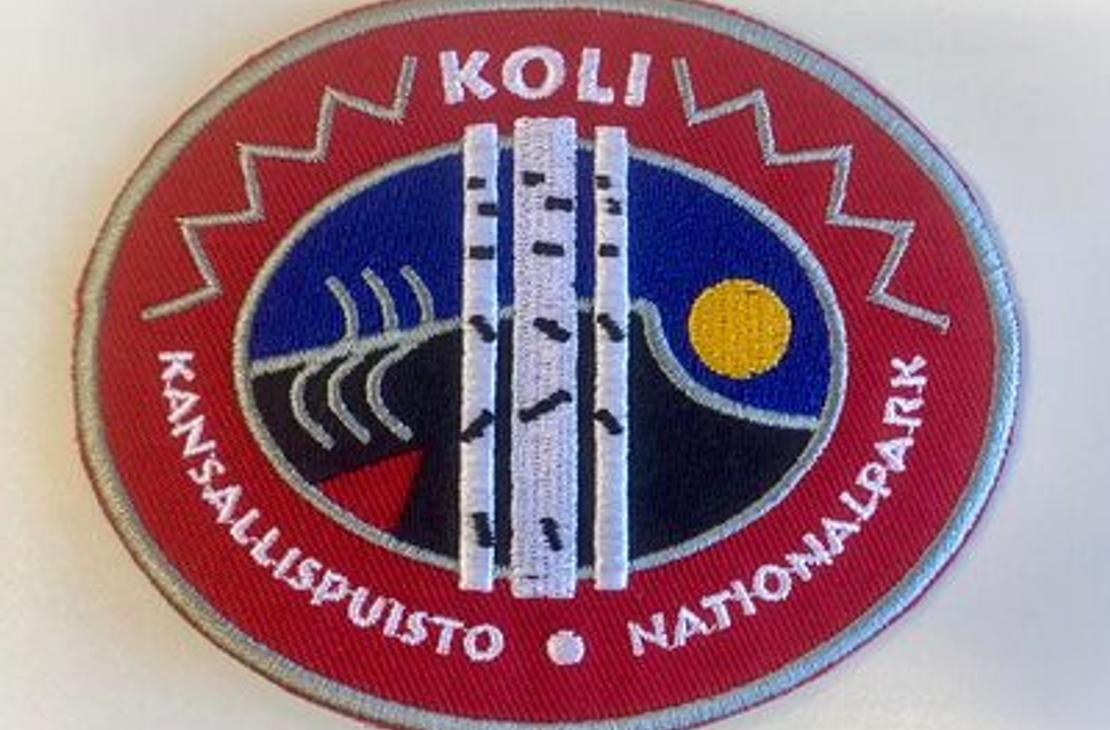 Koli Kansallispuisto -kangasmerkki, jossa kansallispuiston logo 