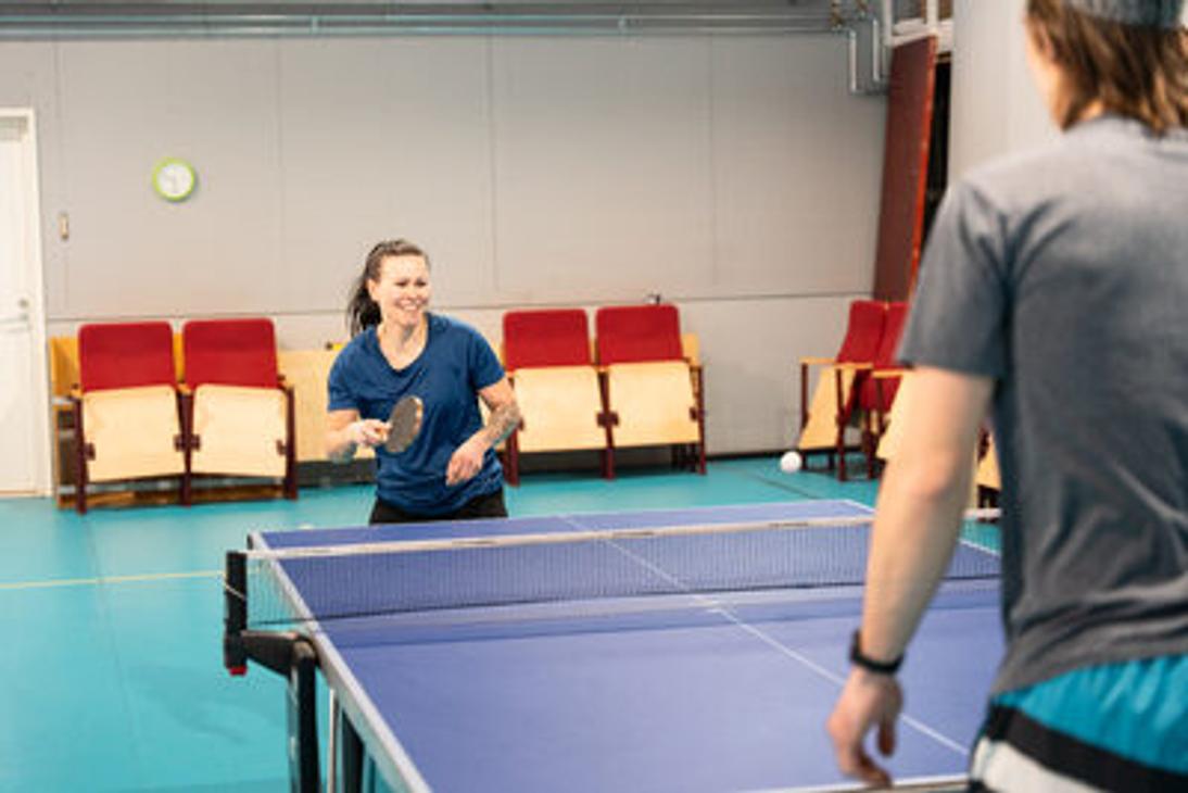 Pöytätenniksen pelaajat liikuntahallilla