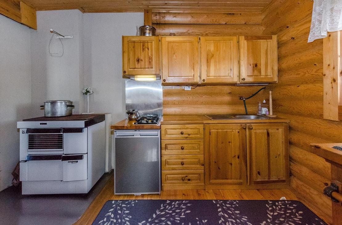 Keittiönurkkaus, jossa kaapit ja puuhella