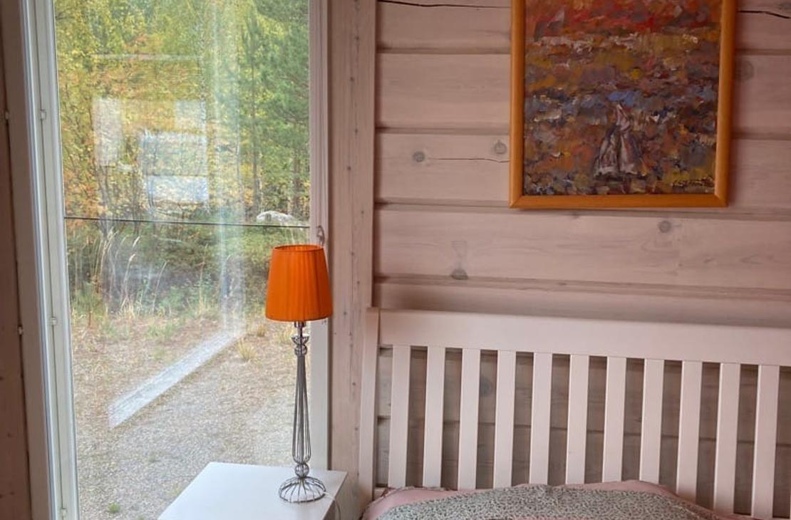 Vaaleanpuna-vihre&auml;-valkoinen tilkkupeitto s&auml;ngyll&auml;, vierell&auml; maisemaikkuna