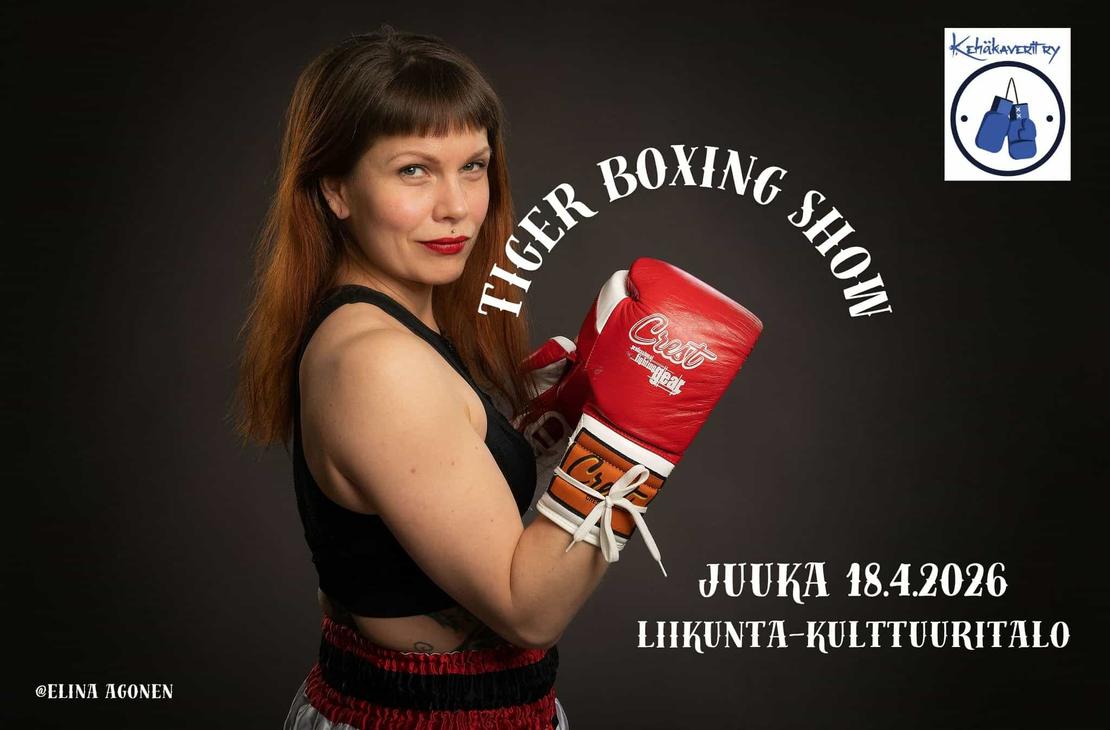 Naisnyrkkeilijä poseeraa punaiset hanskat pystyssä.