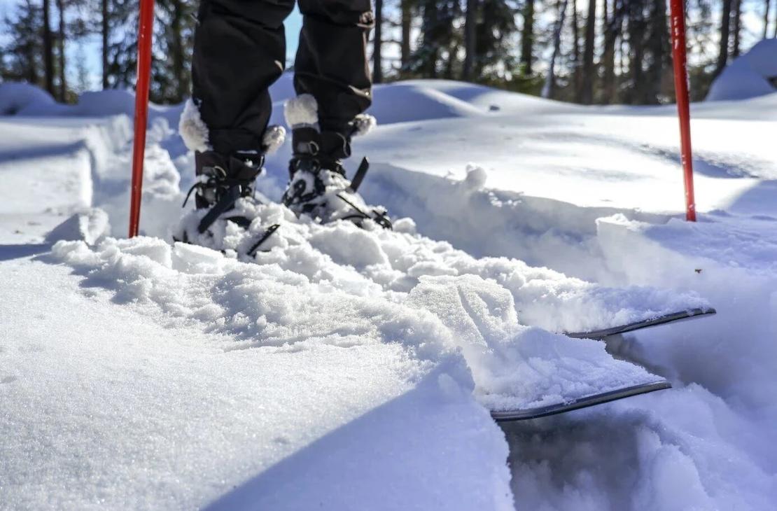 Liukulumikengät aurinkoisella hangella