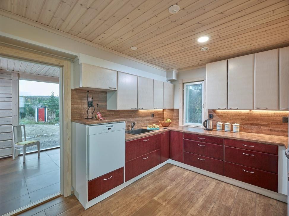 Keittiö on kahdella seinällä. Punaiset alakaapit ja valkoiset yläkaapit