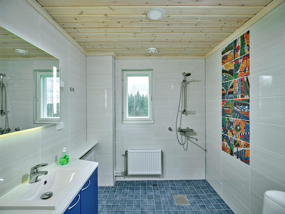 Kylpyhuone, jossa sininen lattia ja valkoiset sein&auml;t