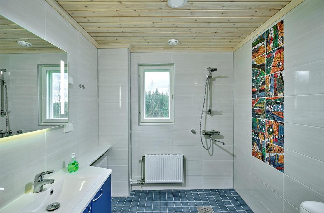 Kylpyhuone, jossa sininen lattia ja valkoiset sein&auml;t