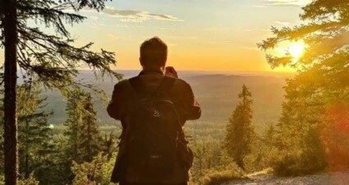 Retkeilijä auringonlaskun aikaan Kolin vaaroilla