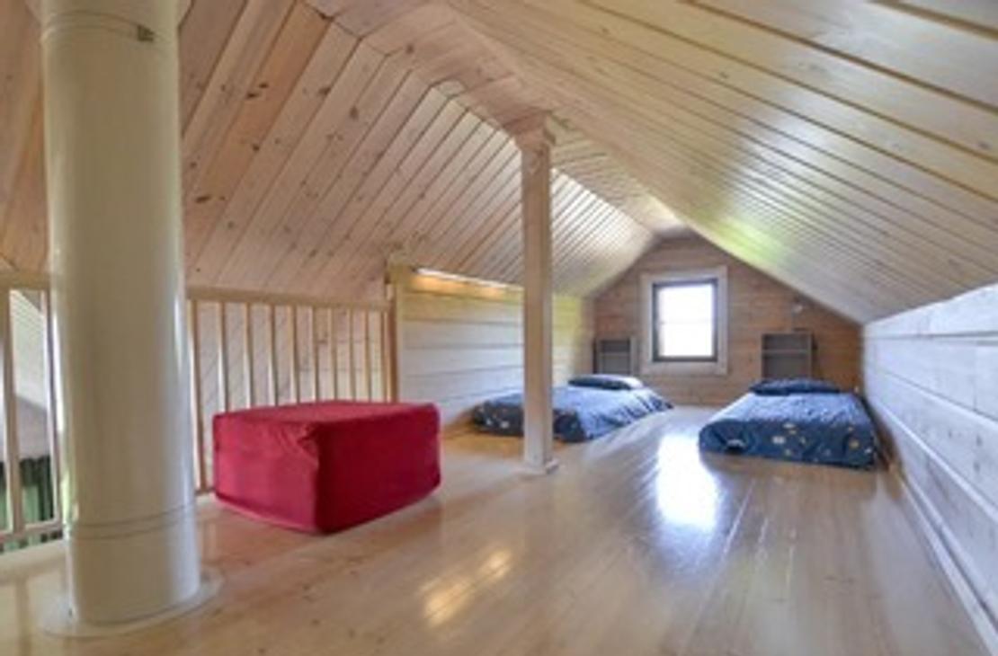 Vaalean puun sävyinen parvi, jossa kaksi patjasänkyä.