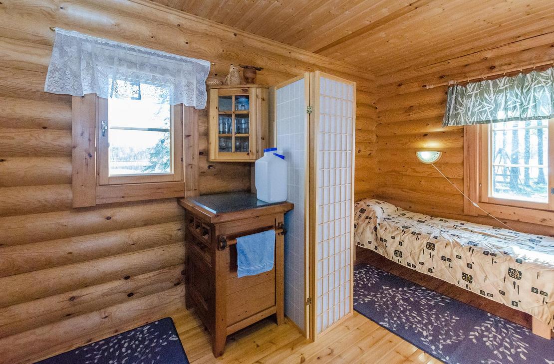 Hirsiseinäinen huone, jossa sermillä erotettava nukkumasoppi