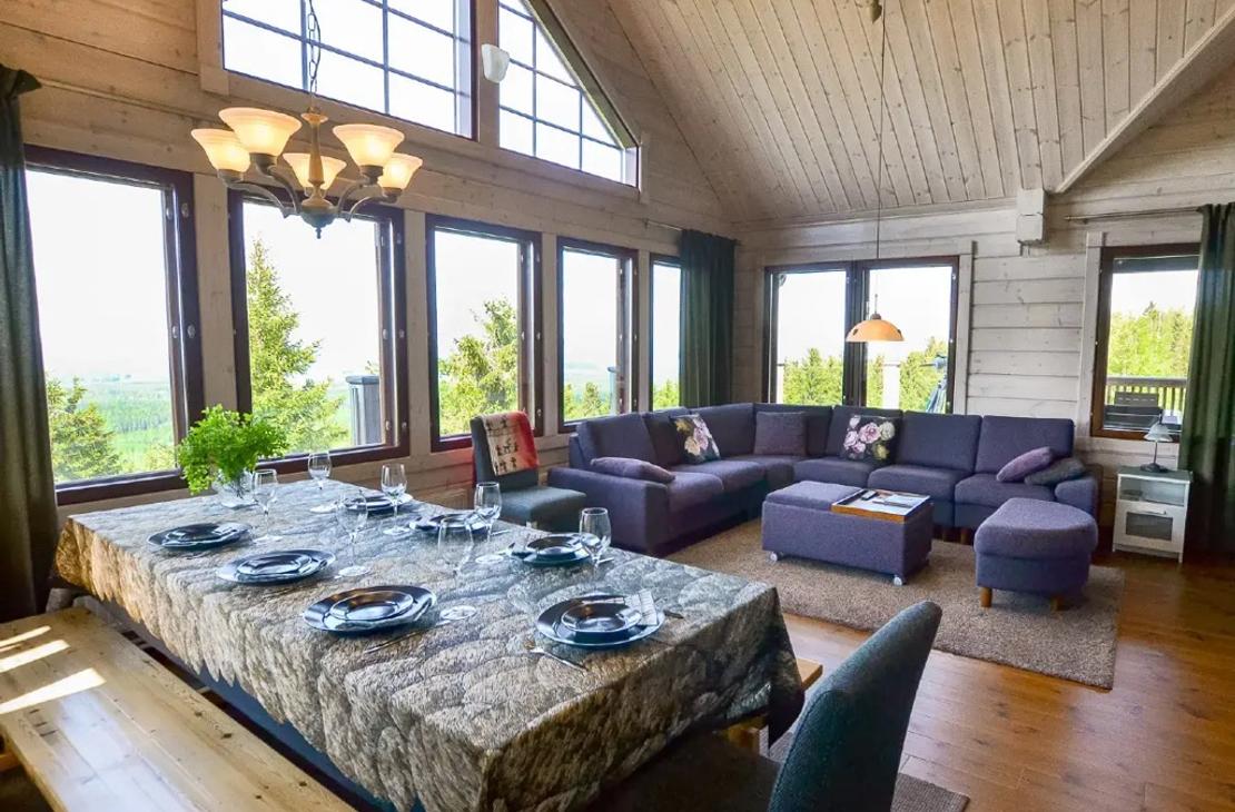 Avara ruokailu- ja oleskelutila, jossa suuret ikkunat 