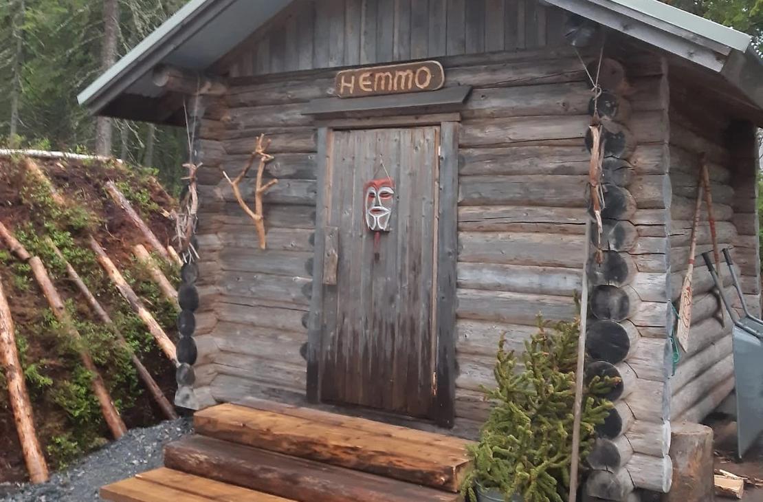 Harmaaksi sävyttynyt hirsinen hemmosauna ulkoa