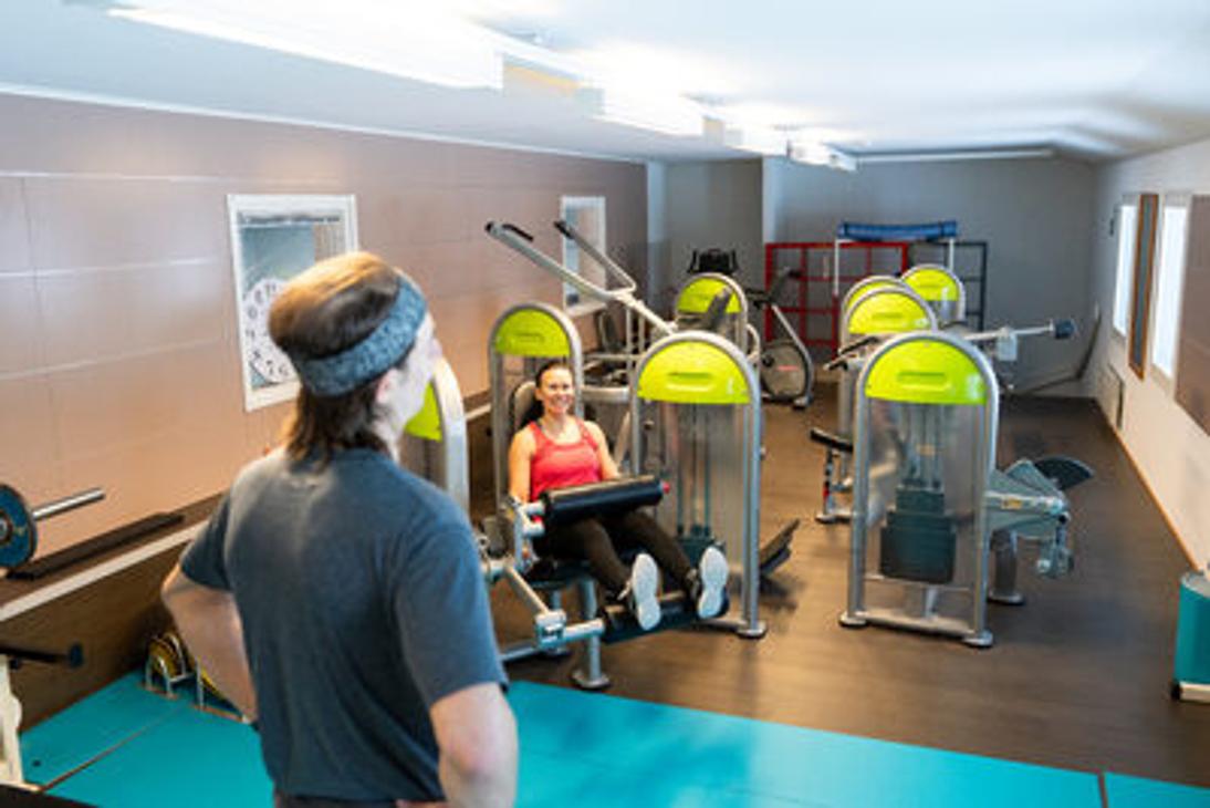 Kolikeskuksen kuntosalin painolaitteita ja salin yleisnäkymä salilta