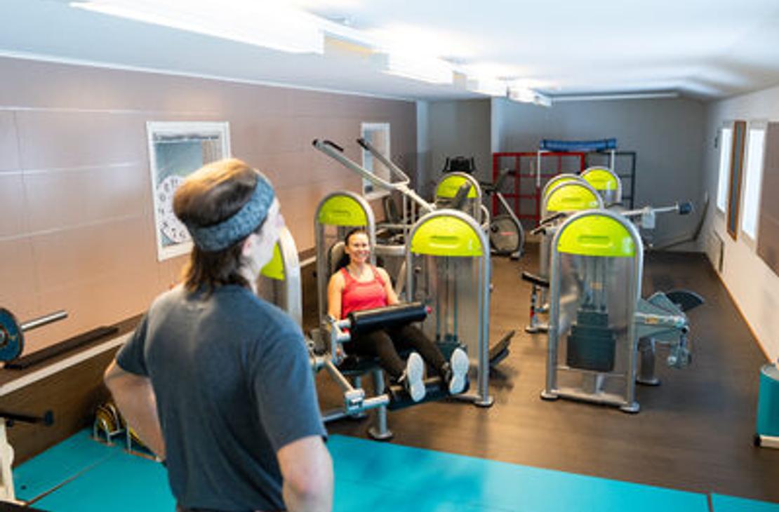 Kolikeskuksen kuntosalin painolaitteita ja salin yleisnäkymä salilta