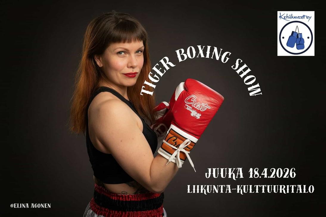 Naisnyrkkeilijä poseeraa punaiset hanskat pystyssä.