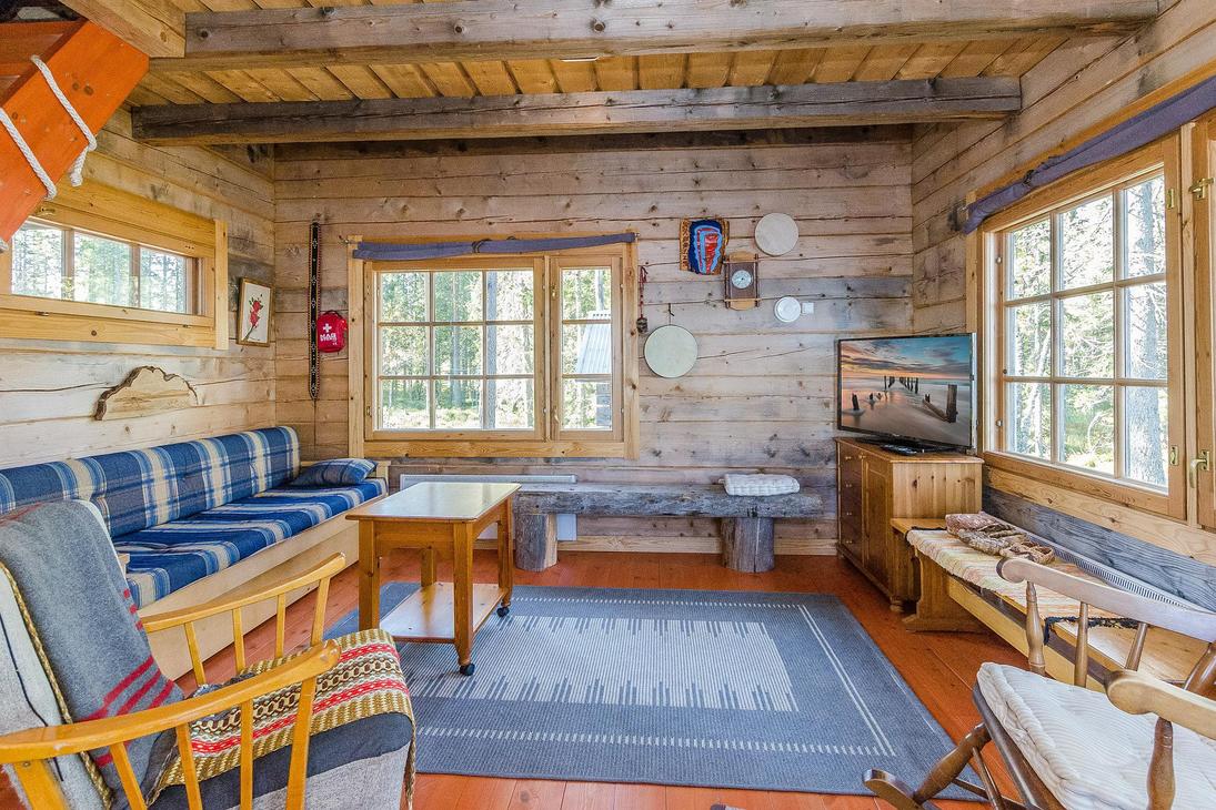 Hirsimökin oleskelutila, jossa levitettävä sohva