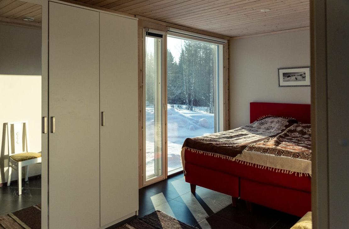 Päämakuuhuone punainen levää parisänky ja vaaleat puuseinät