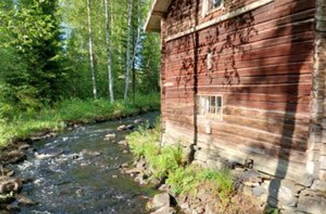 Venejoen Myllyn punainen hirsiseinä auringonvalossa