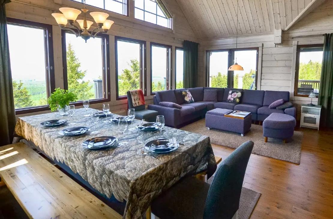 Avara ruokailu- ja oleskelutila, jossa suuret ikkunat 