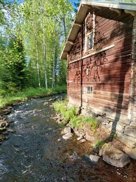 Venejoen Myllyn punainen hirsiseinä auringonvalossa