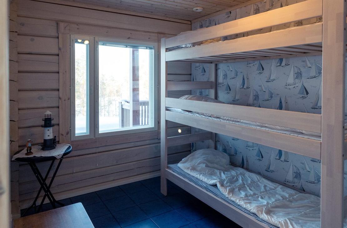 Sini-harmaan s&auml;vyinen vaalea makuuhuone, jossa kolmikerross&auml;ngyt