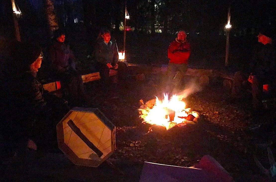 Ihmis&auml; nuotion ymp&auml;rill&auml; illan pimeydess&auml; nuotion ja kynttil&ouml;iden valaistessa vain hieman