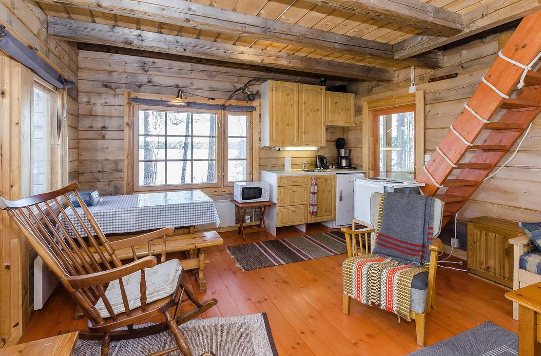 Hirsimökin tupakeittiö, jossa pirtinpöytä ja kiikkutuoli