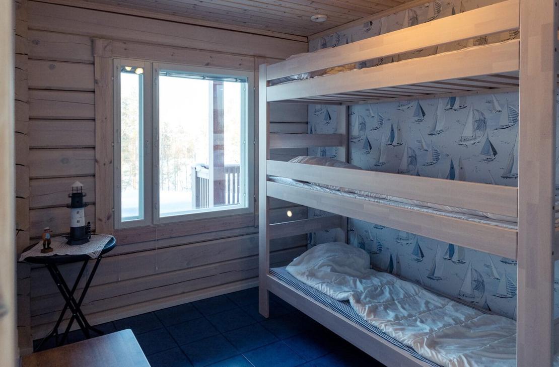 Sini-harmaan s&auml;vyinen vaalea makuuhuone, jossa kolmikerross&auml;ngyt